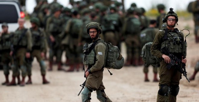 Un pelotón de soldados israelíes se prepara para salir a patrullar en la frontera entre Israel y Gaza. Foto: Atef Safadi / EFE