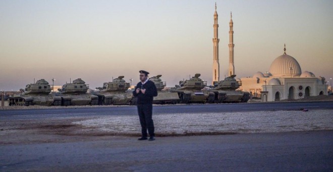 Un oficial de policía, junto a una fila de tanques cerca de la recién inaugurada mezquita Al-Fattah Al-Alim. -  ANDREW CABALLERO-REYNOLDS / POOL / AFP