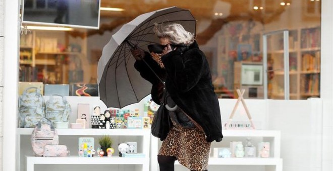 Una mujer se protege de la lluvia caída hoy en Lugo. El jueves llegará a Galicia un frente frío con el avance del día, de forma que los cielos estarán nublados en general, con lluvias que comenzarán por el oeste durante la mañana y que se extenderán al re