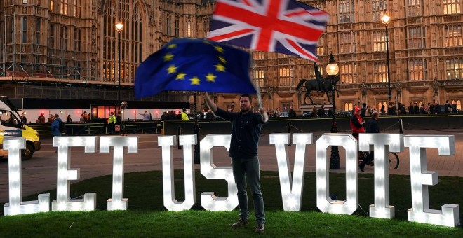 Un manifestante anti-Brexit ondea banderas frente a las Casas del Parlamento en Londres, | Reuters