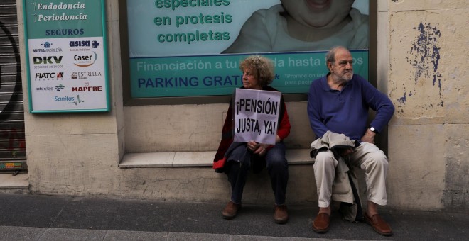 Un hombre y una mujer descansan tras participar en una manifestación reclamando pensiones justas. REUTERS/Susana Vera