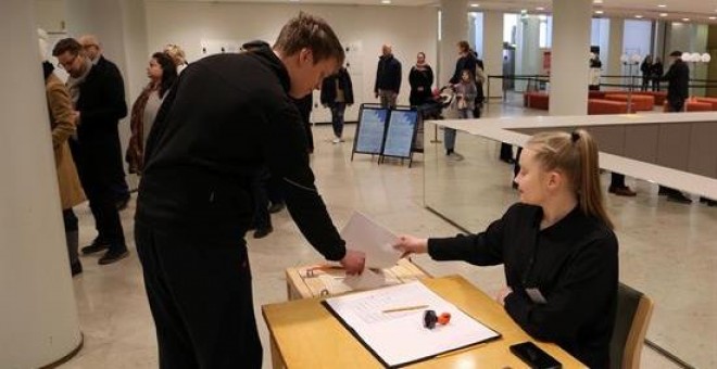 Un votante introduce su papeleta en la urna en el centro de votación del Ayuntamiento de Helsinki durante las elecciones parlamentarias del domingo en Finlandia / EFE