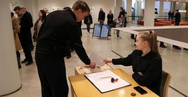 Un votante introduce su papeleta en la urna en el centro de votación del Ayuntamiento de Helsinki durante las elecciones parlamentarias del domingo en Finlandia / EFE