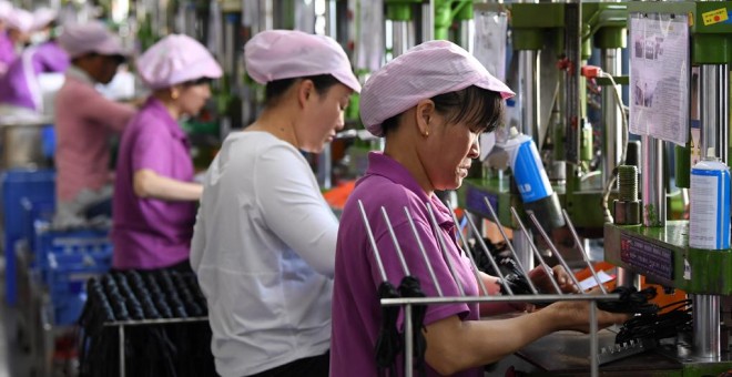 Mujeres trabajadores en una línea de producción de cable de datos en una fábrica en Xinyu, provincia de Jiangxi, China. REUTERS / Stringer