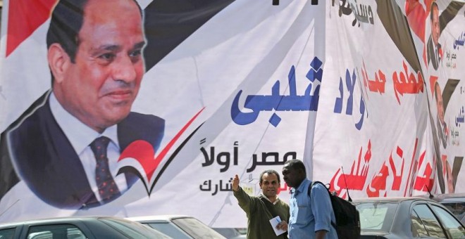 09/04/2019 - Dos hombres frente a un cartel del presidente egipcio Abdel Fattah al-Sisi días antes del referéndum para reformar la Constitución. / REUTERS - MOHAMED ABD EL GHANY