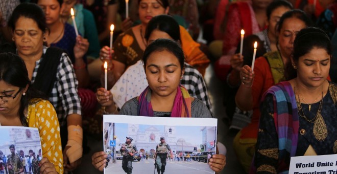 22/04/2019 - Maestros sostienen velas mientras rezan por las víctimas de los atentados en Sri Lanka en una escuela en Ahmedabad, India | REUTERS/ Amit Dave