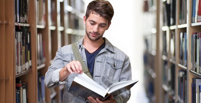 Un estudiante consulta un libro en la biblioteca. Foto: Pixabay