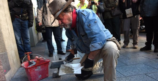 El artista alemán Gunter Demmig instalando una de las piedras de la Memoria en Madrid este viernes.- FERNANDO SÁNCHEZ