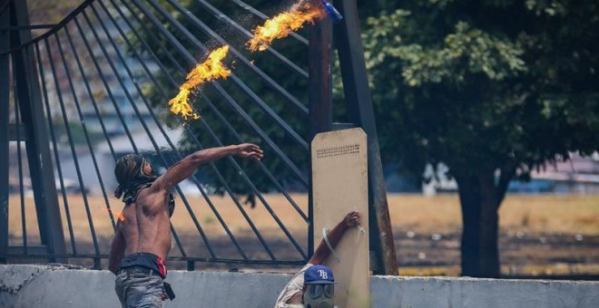 Opositores se enfrentan con la policía en una manifestación este miércoles en las calles de Caracas (Venezuela). /EFE