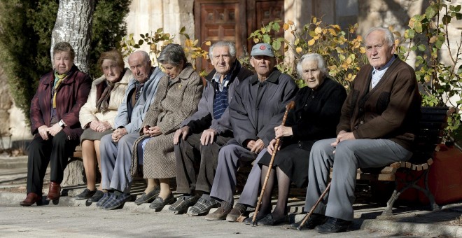 Ancianos y ancianas toman el sol en unos bancos | EFE/ Archivo