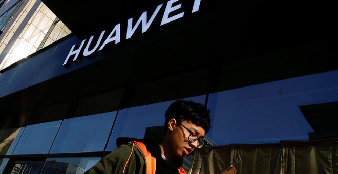 Imagen de un usuario de móvil frente a una tienda de Huawei. REUTERS