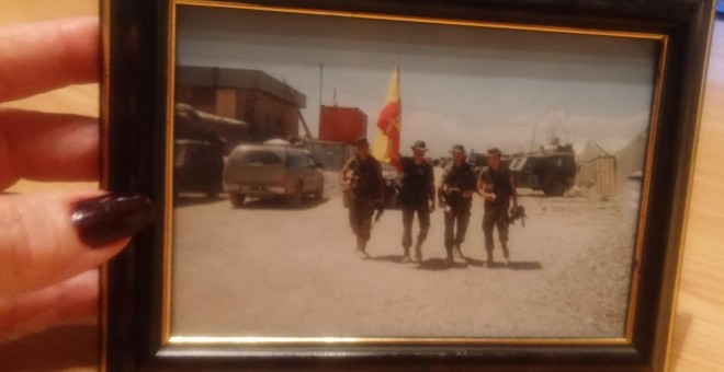 Mari Paz Fernández sostiene una foto de su marido, el comandante José Manuel Ripollés (sujetando la bandera) tomada en Afganistán antes de fallecer en acto de servicio en el siniestro del ak-42 en 2003. PÚBLICO