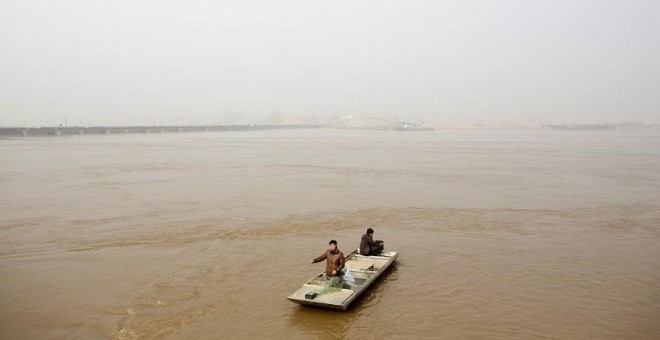 Los pescadores Sun Lianxi, de 32 años, y Sun Genxi, de 44 años, viajan por el río Amarillo para echar su red en las afueras del norte de Zhengzhou, en la provincia china de Henan. REUTERS/Thomas Peter