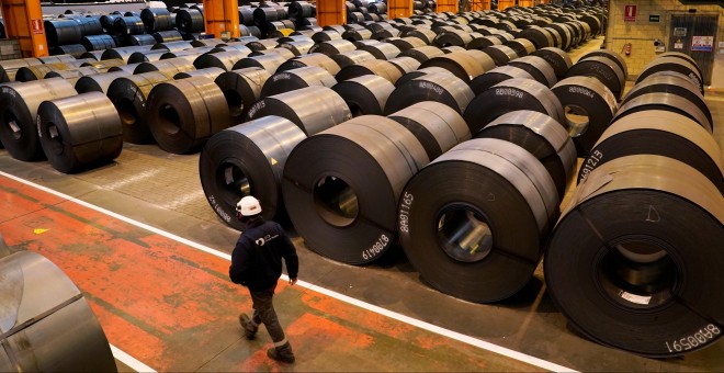 Un trabajador pasa junto a las bobinas de acero en la planta de ArcelorMittal en Sestao (Vizcaya). REUTERS