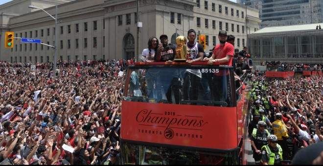 Los jugadores de los Raptors entre la multitud que celebraba el título de la NBA en Toronto. - REUTERS