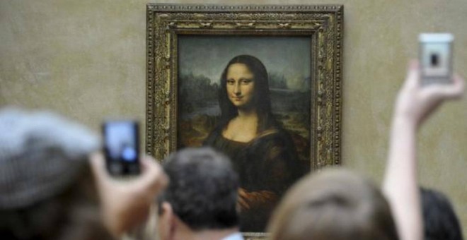 Un grupo de turistas fotografía 'La Gioconda' en el Museo del Louvre, en París.- EFE