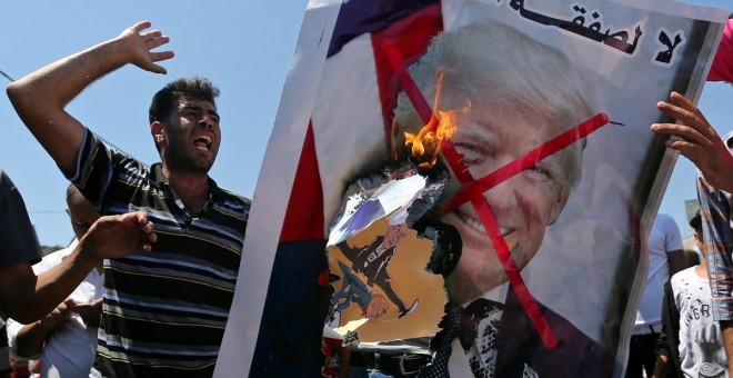 26/06/2019 - Palestinos queman una fotografía del presidente de EEUU, Donald Trump, como protesta contra la cumbre de Bahrein. / REUTERS - IBRAHEEM ABU MUSTAFA