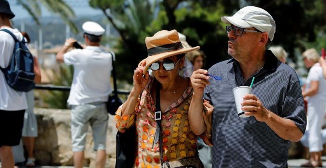 Una pareja de turistas pasea por las calles de Palma de Mallorca bajo el intenso calor.- EFE/Clara Margai