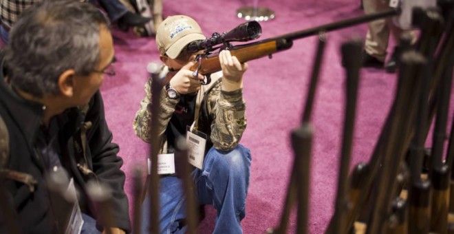 Un niño coge un arma en EEUU. REUTERS/Archivo