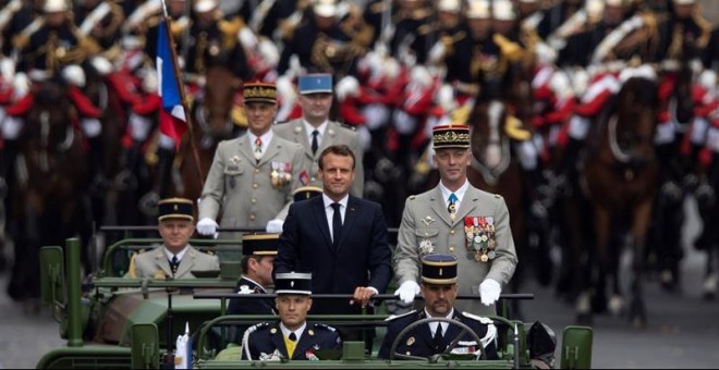 El presidente francés, Emmanuel Macron, a bordo del vehículo militar, flanqueado por la Guardia Repulblicana montada, asiste al desfile militar anual del Día de la Bastilla en la avenida de los Campos Elíseos en París.  EFE / IAN LANGSDON