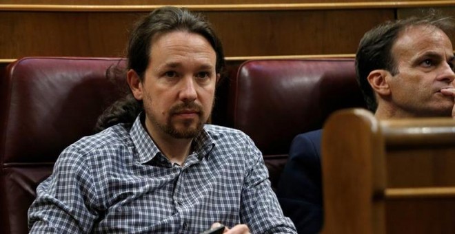 El líder de Unidas Podemos, Pablo Iglesias (izda), en su escaño del hemiciclo del Congreso