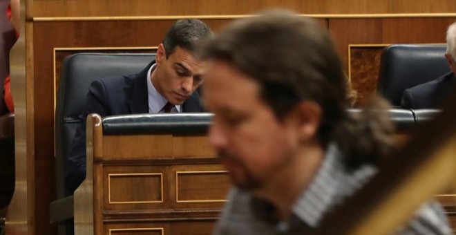 Pablo Iglesias, de camino a la tribuna del Congreso mientras Pedro Sánchez toma unas notas. (J.J. GUILLÉN | EFE)