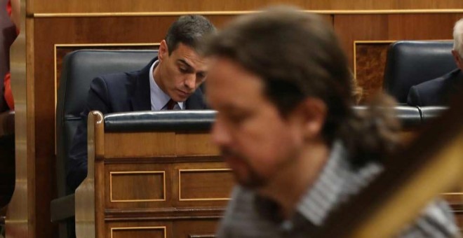 Pablo Iglesias, de camino a la tribuna del Congreso mientras Pedro Sánchez toma unas notas. (J.J. GUILLÉN | EFE)