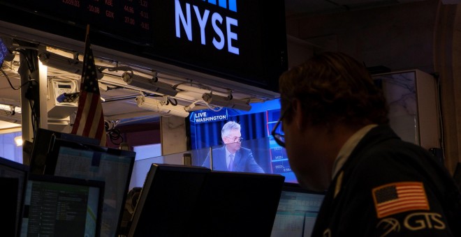 Un operador de la bolsa de ueva York (NYSE, según sus siglas en inglés), observa en un monitor la rueda de prensa del presidente de la Rserva Federal, Jerome Powell, tras la reunión en la que se decidió la primera bajada de los tipos de interés desde 2008