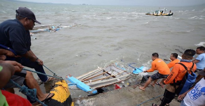 Guardacostas filipinos sacan del agua restos de un bote que naufragó cerca de la costa de la isla Guimaras, el día anteir, en la region de Bisayas este domingo.  EFE/ Leo Solinap