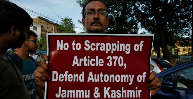 Un hombre muestra una pancarta durante una protesta contra la eliminación del estatus constitucional especial para Cachemira, en India | Reuters