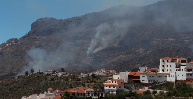 11/08/2019.- Vista del pueblo de Tejeda y detrás uno de los focos del incendio que arrasa este domingo los municipios de Tejeda, Artenara y Gáldar, en Gran Canaria. EFE/Elvira Urquijo A.
