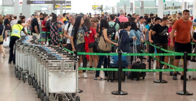 Pasajeros en tránsito durante la tercera jornada de huelga de este domingo en El Prat. / EFE