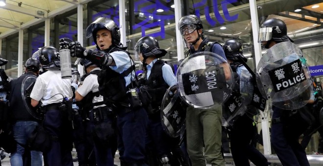 La policía antidisturbios usa spray de pimienta para dispersar a los manifestantes contra el proyecto de ley de extradición durante una manifestación masiva después de que una mujer recibió un disparo en el ojo, en el aeropuerto internacional de Hong Kong