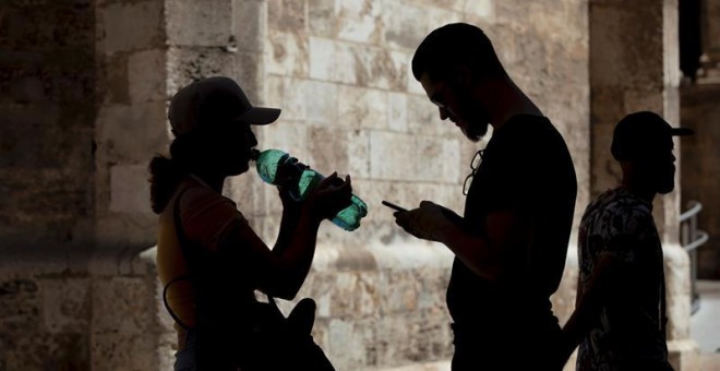 14/08/2019 - Una mujer bebe agua de una botella en el centro histórico de València / EFE (BIEL ALIÑO)