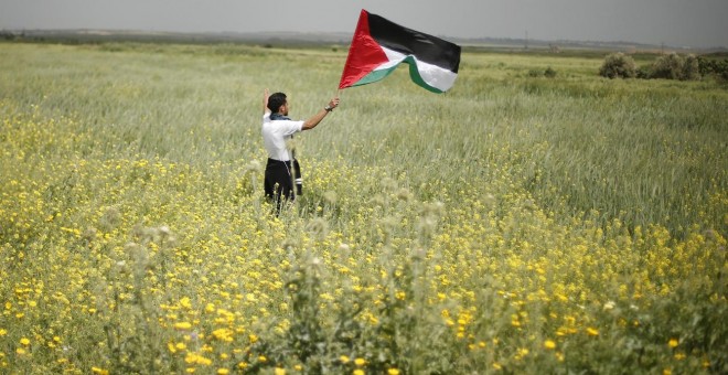 Un hombre ondea la bandera palestina en los territorios de Gaza. REUTERS