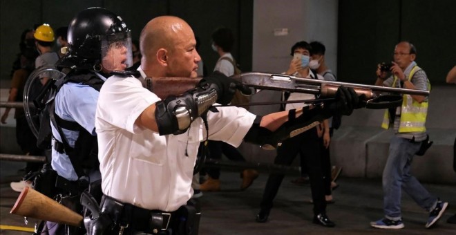 Un oficial de policía de Hong Kong apunta con un arma a los manifestantes. / TYRONE SIU (REUTERS)