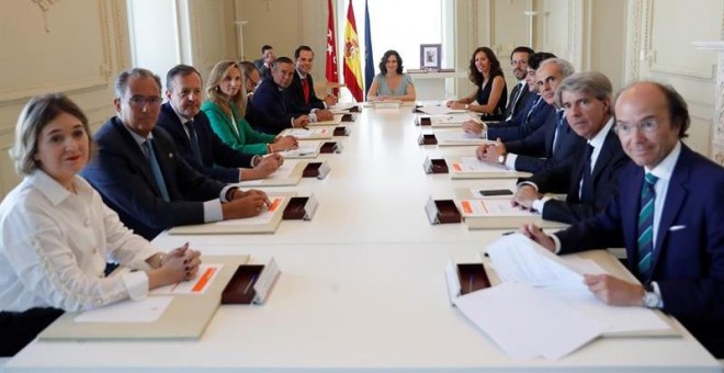 , 20/08/2019.- La presidenta de la Comunidad de Madrid, Isabel Díaz Ayuso (fondo), durante la primera reunión del nuevo Ejecutivo autonómico de coalición del PP y Ciudadanos tras la toma de posesión de los consejeros, este martes en la sede de la Presiden