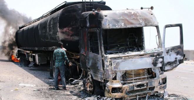 Un hombre inspecciona un camión incendiado durante los enfrentamientos en el sur de Yemen. / Reuters