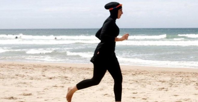 Una mujer con 'burkini', en la playa.- REUTERS