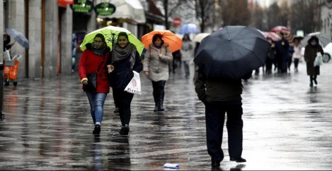 Imagen de archivo de ciudadanos paseando el frío y la lluvia. EUROPA PRESS/Óscar del Pozo