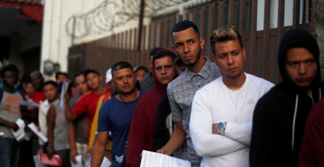 Un grupo de migrantes hace cola en la Comisión Mexicana de Asistencia a Refugiados (COMAR) en Tapachula. REUTERS/Jose Cabezas