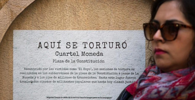 Una mujer se manifiesta este 10 de septiembre frente a un cartel que conmemora uno de los centros de tortura de la dictadura de Augusto Pinochet en Santiago de Chile Alberto Valdés / EFE