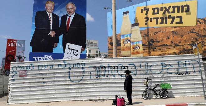 16/09/2019 - Un judío ortodoxo mira un cartel de la campaña que muestra al primer ministro israelí Benjamin Netanyahu y al presidente estadounidense, Donald Trump. / REUTERS - AMMAR AWAD