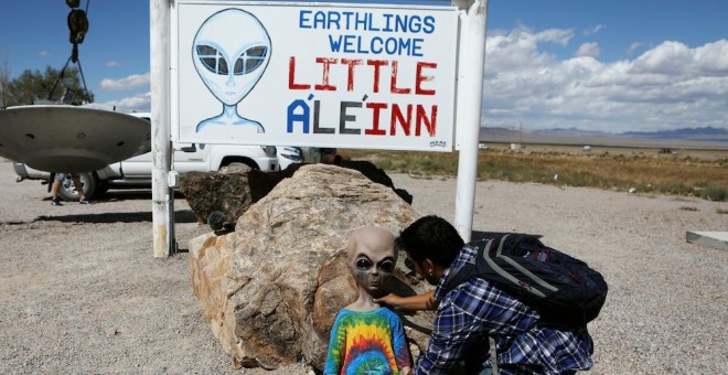 Uno de los asistentes a la convocatoria 'Asalto al Área 51' coloca un muñeco extraterrestre en el suelo del hotel A'Le'Inn, en la localidad de Rachel, Nevada, EEUU. REUTERS