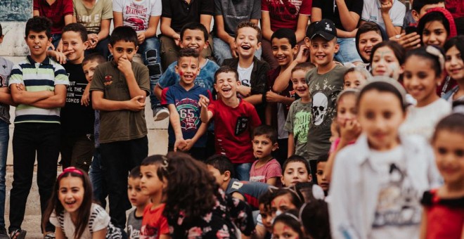 Los niños palestinos ríen durante la actuación de Ivan Prado. BERNAT ALMIRALL.