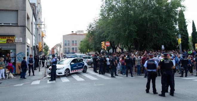 Mossos d'Esquadra controlan a la multitud que se ha congregado ante el domicilio en el que agentes de la Guardia Civil llevan a cabo un registro en Sabadell (Barcelona). /EFE