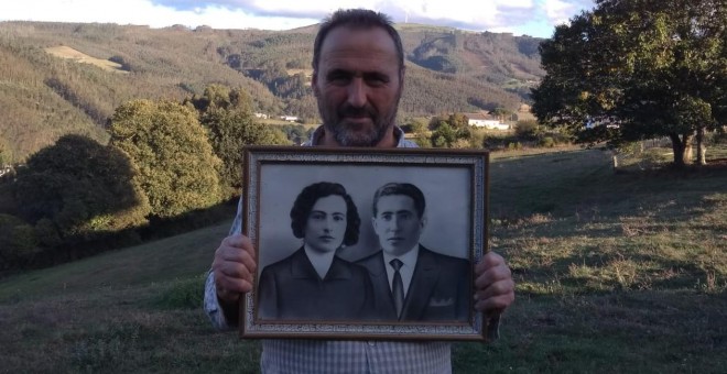 Pedro Amago sujeta el retrato del alcalde socialista Clemente Amago y su mujer, Regina Llenderozos.