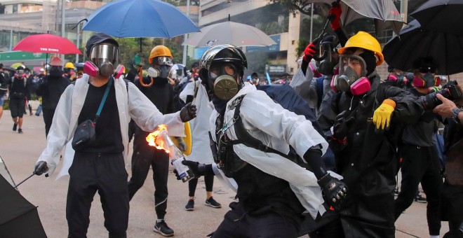 Un manifestante antigubernamental arroja un cóctel molotov a la policía durante una protesta en el Día Nacional en Hong Kong. EFE / EPA / FAZRY ISMAIL