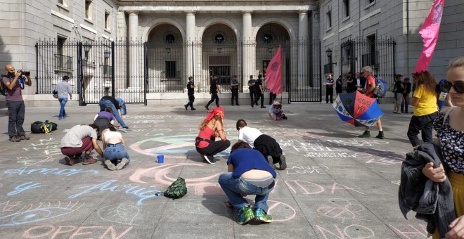 Algunos activistas han pintado con tiza mensajes reivindicativos frente a la entrada del Ministerio para la Transición Ecológica. | Foto: G. M. M.