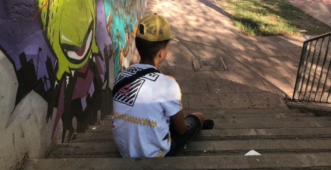 Hakim (nombre ficticio), sentado en un parte del barrio de Hortaleza de Madrid. Asegura ser uno de los chicos migrantes agredidos con remos por dos enmascarados.- JAIRO VARGAS